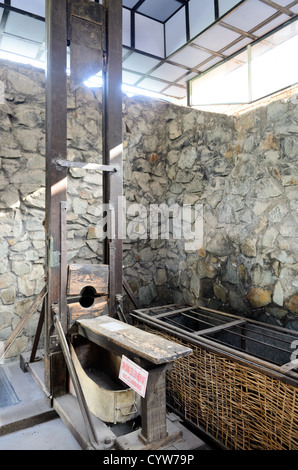Kriegsrelikten-Museum Französische Holz-Gilotine Eiserner Tigerkäfig Ho-Chi-Minh-Stadt Vietnam | HO-CHI-MINH-STADT, Vietnam — Das Kriegsrelikten-Museum zeigt eine Guillotine aus der französischen Kolonialzeit neben einem eisengitterverschlossenen Tigerkäfig. Die Guillotine, die zur Unterdrückung früherer antikolonialer Aufstände importiert wurde, wurde später von der Regierung Ngo Dinh Diems unter Gesetz 10/59 eingesetzt, um mutmaßliche Kommunisten hinzurichten — Berichten zufolge wurde sie zuletzt 1960 verwendet. Der angrenzende niedrige Käfig demonstriert die Einschließungsmethoden des Gefängnisses Con Dao, mit schweren Obergittern, die Häftlingen permanent das Aufrechtstehen verhinderten. Stockfoto