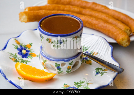 Heiße Schokolade serviert in einer verzierten Porzellantasse, mit spanischen porras Stockfoto