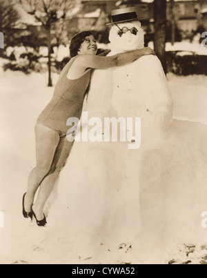 Jahrgang 1930 Pressefoto jungen Frau umarmt Schneemann vor dem Schlafengehen im Wasser schwimmen, Manhattan Beach, New York, USA Stockfoto
