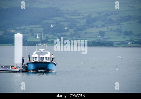 BEAUMARIS, Anglesey, Wales – Pier und Anlegesteg bei Beaumaris mit malerischem Blick auf die Menai-Straße und die nahe gelegenen Snowdonia-Berge. Dieser beliebte Ort am Wasser dient als Anlegepunkt für Boote und ist ein Schlüsselelement des Küstencharms der Stadt. Der Pier wird von Besuchern besucht, die Bootstouren Unternehmen und die ruhige maritime Umgebung genießen. Stockfoto