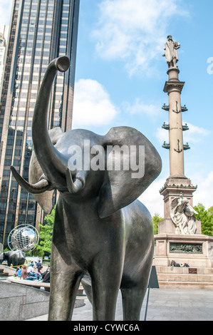 NEW YORK, NY, USA – Eine lebensgroße Bronze-Elefanten-Skulptur des Künstlers Peter Woytuk steht am Broadway als Teil einer öffentlichen Kunstausstellung mit Wildtieren. Im Hintergrund erhebt sich das hochaufragende Columbus Monument, das eine markante Gegenüberstellung zwischen der urbanen Landschaft und der naturalistischen Kunstinstallation schafft. Diese einzigartige Ausstellung verwandelt die belebte Straße in eine Open-Air-Galerie und bringt Kunst und Natur ins Herz von Manhattan. Stockfoto