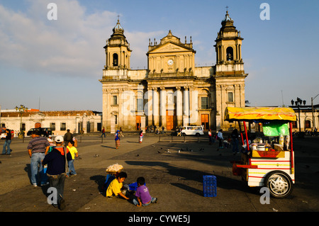 Straßenhändler in Parque Central (offiziell die Plaza De La Constitución) im Zentrum von Guatemala-Stadt, Guatemala, mit der Catedral Metropolitana im Hintergrund. Stockfoto