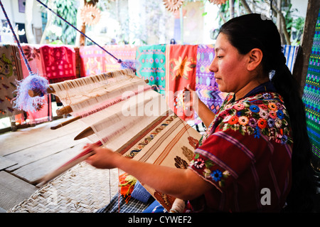 ANTIGUA GUATEMALA, Guatemala – Frau, die einen traditionellen Webstuhl im Casa del Tejido Antiguo nutzt, einem indigenen Textilmuseum und Markt in Antigua, Guatemala Stockfoto