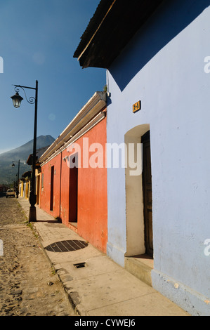 ANTIGUA GUATEMALA, Guatemala – im Vordergrund steht die traditionelle spanische Kolonialarchitektur Antiguas, im Hintergrund ragt der Volcán de Agua (oder der Vulkan Agua). Antigua Guatemala ist berühmt für seine gut erhaltene spanische Barockarchitektur sowie eine Reihe von Erdbebenruinen und gehört zum UNESCO-Weltkulturerbe und ehemalige Hauptstadt Guatemalas. Stockfoto