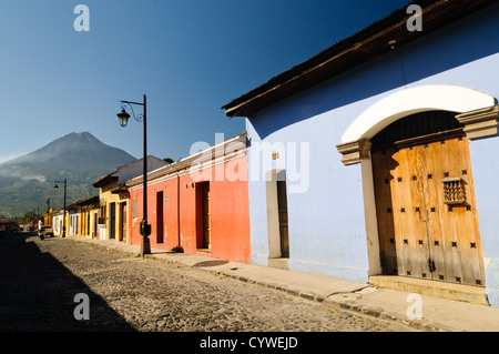 ANTIGUA GUATEMALA, Guatemala – im Vordergrund steht die traditionelle spanische Kolonialarchitektur Antiguas, im Hintergrund ragt der Volcán de Agua (oder der Vulkan Agua). Antigua Guatemala ist berühmt für seine gut erhaltene spanische Barockarchitektur sowie eine Reihe von Erdbebenruinen und gehört zum UNESCO-Weltkulturerbe und ehemalige Hauptstadt Guatemalas. Stockfoto