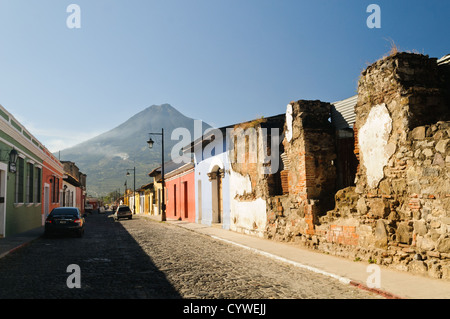 ANTIGUA GUATEMALA, Guatemala – im Vordergrund steht die traditionelle spanische Kolonialarchitektur Antiguas, im Hintergrund ragt der Volcán de Agua (oder der Vulkan Agua). Antigua Guatemala ist berühmt für seine gut erhaltene spanische Barockarchitektur sowie eine Reihe von Erdbebenruinen und gehört zum UNESCO-Weltkulturerbe und ehemalige Hauptstadt Guatemalas. Stockfoto