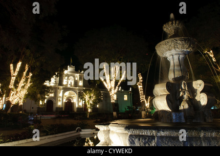 ANTIGUA GUATEMALA, Guatemala – Lichterketten sind um die Bäume auf dem zentralen Stadtplatz in Antigua Guatemala gewickelt. Antigua Guatemala ist berühmt für seine gut erhaltene spanische Barockarchitektur sowie eine Reihe von Erdbebenruinen und gehört zum UNESCO-Weltkulturerbe und ehemalige Hauptstadt Guatemalas. Stockfoto