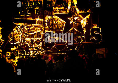 Lagerfeuer-Prozession zur Erinnerung. Tausende von Zuschauern Linie der Straßen von der winzigen East Sussex Dorf von East Hoathly in der Nähe von Lewes, UK Uhr Feuer Banner in Flammen als einen Akt der Erinnerung auf dem Weg in eine riesige Holzskulptur Lagerfeuer und Feuerwerk Anzeige durchgeführt. Stockfoto