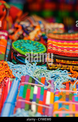 ANTIGUA GUATEMALA, Guatemala – auf einem Markt in Antigua Guatemala stapeln sich bunte gewebte Textilien. Guatemala hat eine sehr starke Tradition in der Handweberei mit verschiedenen Arten von Webstühlen. Antigua Guatemala ist berühmt für seine gut erhaltene spanische Barockarchitektur sowie eine Reihe von Erdbebenruinen und gehört zum UNESCO-Weltkulturerbe und ehemalige Hauptstadt Guatemalas. Stockfoto