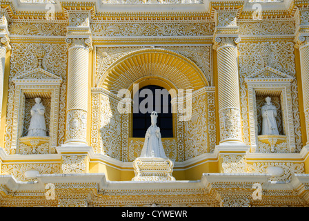 ANTIGUA, Guatemala - das Äußere von Iglesia y Convento de Nuestra Señora de la Merced, ein bemerkenswertes Beispiel der guatemaltekischen Barockarchitektur. Dieser religiöse Komplex aus dem 18. Jahrhundert, bekannt für seine markante gelbe Fassade und kunstvoll verzierte weiße Stuckarbeiten, ist ein Beleg für Antiguas reiche Kolonialgeschichte und ein bedeutender Ort der katholischen Verehrung. Stockfoto