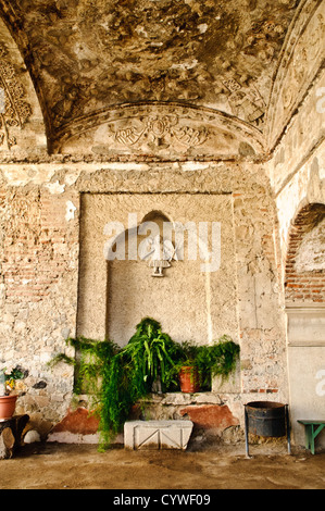 ANTIGUA GUATEMALA, Guatemala — Teil des Freiluftklosters von Iglesia de San Francisco, einer spanischen Kolonialkirche in Antigua, Guatemala. Das historische Gebäude, das im 16. Jahrhundert erbaut und 1773 teilweise durch Erdbeben zerstört wurde, ist mit kunstvollen barocken Schnitzereien geschmückt. Wetter und Zeit haben die dekorativen Elemente verwittert, mit sichtbaren Anzeichen von Verfall, die das Mauerwerk beeinflussen. Die Kirche ist nach wie vor eines der bedeutendsten religiösen Wahrzeichen Antiguas und fungiert weiterhin als Gotteshaus und als Ort der Anbetung Stockfoto