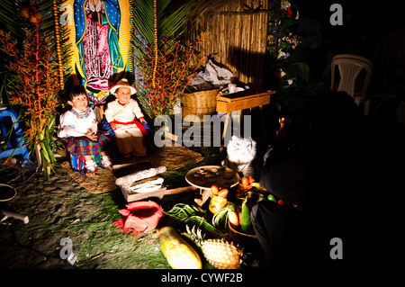 Ein paar Kinder in Anitgua, Guatemala, Pose für Fotos im Kostüm mit einer traditionellen Szene im Hintergrund. Dies war Teil eines Marktes in der Innenstadt von Antigua in der Feier der ein nationaler Feiertag. Stockfoto