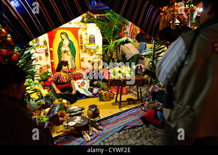 Zwei Kinder in Anitgua, Guatemala, posieren für Fotos im Kostüm mit einer traditionellen Szene im Hintergrund. Dies war Teil eines Marktes in der Innenstadt von Antigua in der Feier der ein nationaler Feiertag. Stockfoto