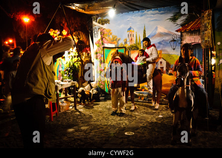 Kinder in Anitgua, Guatemala, posieren für Fotos im Kostüm mit einer traditionellen Szene im Hintergrund. Dies war Teil eines Marktes in der Innenstadt von Antigua in der Feier der ein nationaler Feiertag für Tag der Jungfrau von Guadalupe. Stockfoto