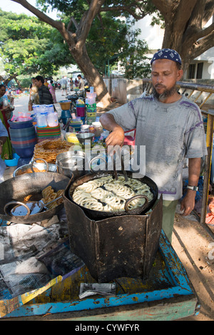 Inder Herstellung und Verkauf von Jalebi [indische süß] bei einer indischen Straßenmarkt. Puttaparthi, Andhra Pradesh, Indien Stockfoto