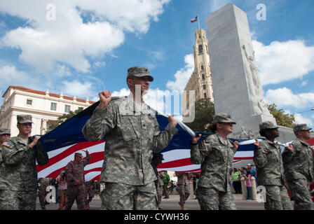 10. November 2012 San Antonio, Texas, USA - Soldaten tragen eine große amerikanische Flagge vorbei an der Alamo-Kenotaph während der Veterans Day parade in San Antonio. Mehr als 15.000 Menschen nahmen an der Parade, die in der Nähe von Alamo begann und endete um Milam Park. Stockfoto