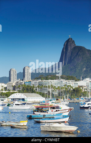 Boote im Hafen festgemacht, mit Christus der Erlöser Statue im Hintergrund, Urca, Rio de Janeiro, Brasilien Stockfoto