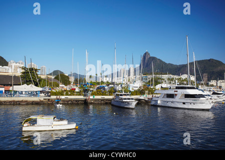 Boote im Hafen festgemacht, mit Christus der Erlöser Statue im Hintergrund, Urca, Rio de Janeiro, Brasilien Stockfoto