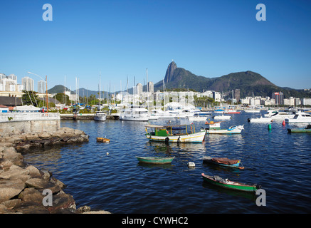 Boote im Hafen festgemacht, mit Christus der Erlöser Statue im Hintergrund, Urca, Rio de Janeiro, Brasilien Stockfoto