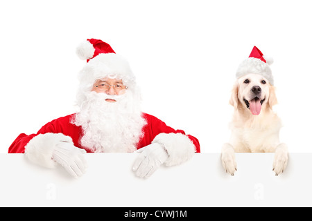 Santa Claus und Hund tragen Weihnachtsmützen und posiert hinter einer Plakatwand isoliert auf weißem Hintergrund Stockfoto