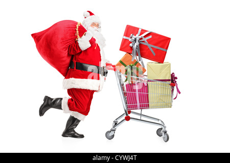 Santa Claus eine Tragetasche und schob ein shopping Warenkorb voller Geschenke isoliert auf weißem Hintergrund Stockfoto