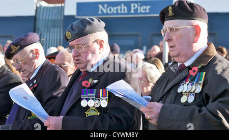 Blackpool, UK 11. November 2012.  Gedenkgottesdienst statt in Blackpool Ehrenmal an der Strandpromenade neben Nordpier. Drei bebrillte ex-Soldaten Tak an das singen. Alamy Live-Nachrichten Stockfoto