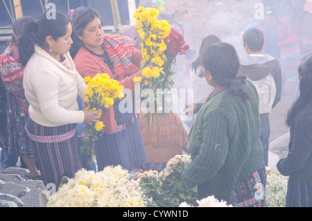 CHICHICASTENANGO, Guatemala - Frauen Blumen verkaufen im Chichicastengo Markt. Sie sind auf den Stufen vor der Kirche Santo Tomas und der Rauch wird aus lokalen Maya Vorbeter (bekannt als chuchkajaues) Weihrauch und copal Harz. Chichicastenango ist eine indigene Maya Stadt im guatemaltekischen Hochland ca. 90 Meilen nordwestlich von Guatemala City und auf einer Höhe von fast 6.500 Metern. Es ist berühmt für seine Märkte Sonntags und Donnerstags. Stockfoto