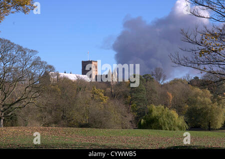 St Albans, UK. 11. November 2012. Dicker schwarzer Rauch steigt hinter St. Albans Kathedrale. Blick von Verulamium Park, St. Albans. Ein Feuer brach am um 12:20 heute, Sonntag, 11. November 2012, Glinwell Kindergarten, Hatfield Road, Smallford. Die Glinwell Räumlichkeiten dort sind seinem Distributionszentrum für ihr Obst und Gemüse Großhandel. Offenbar sind Tausende von Paletten aus Holz und Kunststoff-Behälter am Standort gespeichert.  Um 12:40 hatte eine dicke schwarze Rauchfahne Hunderte von Füßen in die Luft gestiegen. Stockfoto