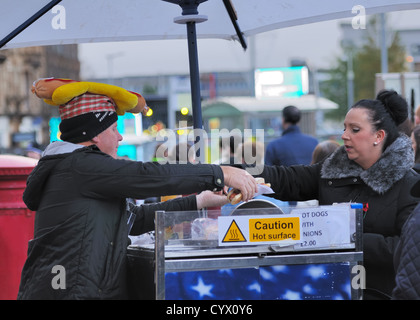 Mann, Verkauf von Hot Dog an Frau in Paisley, Schottland. Stockfoto