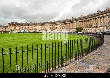 Einem großen begrünten Park vor dem Royal Crescent in Bath, Somerset. Die Royal Crescent ist eine Straße von 30 Reihenhäusern angelegt in einem weitläufigen Halbmond in der Stadt Bath, England. Entworfen von dem Architekten John Wood dem jüngeren und zwischen 1767 und 1774 erbaut, zählt zu den grossartigsten Beispiele georgianischer Architektur im Vereinigten Königreich zu finden und ist eine Klasse, die ich Gebäude unter Denkmalschutz. Obwohl im Laufe der Jahre einige Änderungen zu den verschiedenen Innenräumen vorgenommen wurden, bleibt die georgische Steinfassade viel wie es war, als es gebaut wurde. Stockfoto