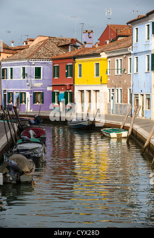 Die späten Nachmittag Sonne leuchten die bunten Häuser von Burano und ihre Überlegungen in einem Kanal Stockfoto