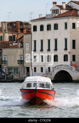 Eine rote Geschwindigkeit Boot Überschrift Weg von der Hauptinsel von Venedig in Richtung der Kamera Stockfoto