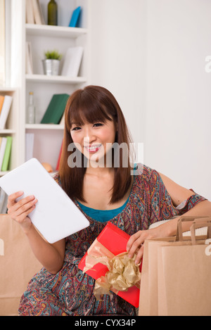 asiatische Mädchen genießen, Online-shopping von zu Hause aus Stockfoto