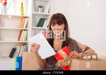 asiatische Mädchen genießen, Online-shopping von zu Hause aus Stockfoto