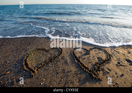 Zwei Herzen an einem Strand in den Sand gezeichnet Stockfoto