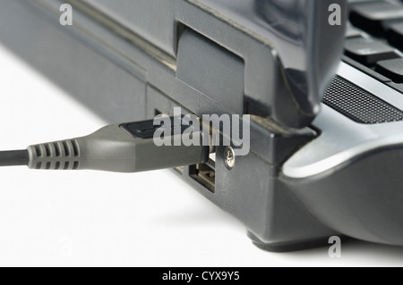 USB-Kabel am USB-Anschluss eines Notebooks Stockfoto