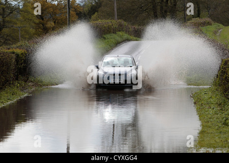 Überfluteten Landstraße mit Autos fahren langsam durch Auto Automobil Automobile Automotive Automóvil Autos britische Gewässer Stockfoto