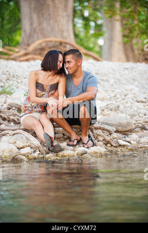 USA, Texas, Leakey, junges Paar sitzt am Ufer Stockfoto