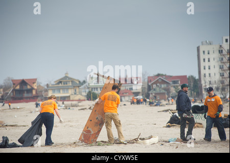 Freiwillige bereinigen Schmutz und Sand abgelagert vom Hurricane Sandy vom Strand und der Promenade Stockfoto