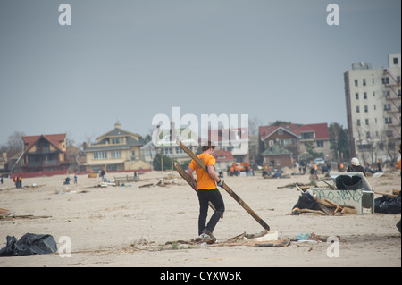 Freiwillige bereinigen Schmutz und Sand abgelagert vom Hurricane Sandy vom Strand und der Promenade Stockfoto