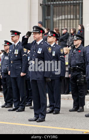 Polizisten Ware Mohn und Stand auf der Hut am Volkstrauertag am Ehrenmal in Vancouvers Siegesplatz. Stockfoto