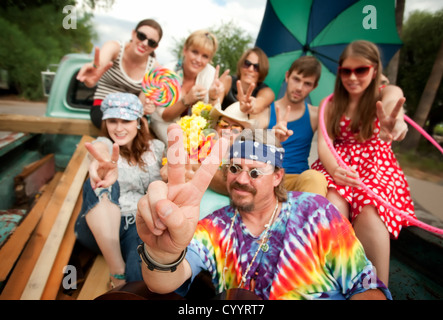 Groovy Gruppe in der Rückseite LKW Making Peace-Zeichen Stockfoto