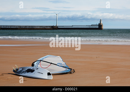 Windsurfer am Strand von Blyth, mit dem Hafen Arme und Windkraftanlage in der Ferne, Northumberland, UK Stockfoto