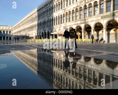 Italien, Venedig, Markusplatz überschwemmt mit Reflexionen von zwei Mädchen, in der Morgensonne Stockfoto