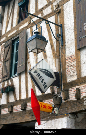 Lampe und Zeichen an der Wand von einem traditionellen Gebäude im Eymet, in der Dordogne-Region Frankreichs. Stockfoto