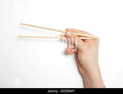 Hand des Mannes greifen Stäbchen auf weißem Hintergrund Stockfoto