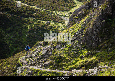Eine junge Frau, die einen großen Rucksack nahe dem Gipfel des Heuhaufen im Lake District. Stockfoto