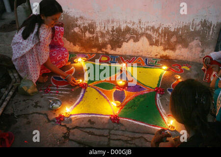 Hindu-Mädchen halten aufhellen irdene Lampen während der Zeremonie hielt Swami Narayan-Tempel in Karachi auf Dienstag, 13. November 2012 Diwali-fest zu feiern. Die Hindu-Gemeinschaft in Pakistan feiert ihr religiöse Fest Diwali.  Mitglieder der Hindu-Gemeinschaft beleuchtet Öllampen außerhalb Tempel, ihre Häuser und Geschäfte, die nach denen Puja Zeremonien in den Tempeln abgehalten wurden. Der Triumph des guten über das Böse, bunte Rangolis (Muster von Farben gemacht) und Feuerwerkskörper sind die Highlights des hinduistischen Festivals. Stockfoto