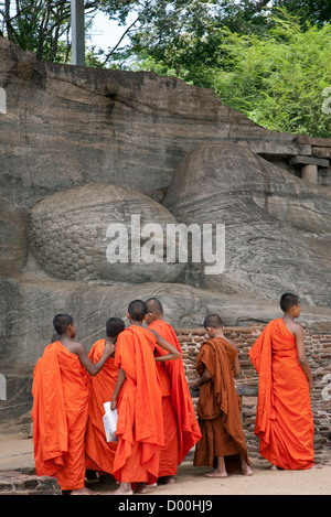 Novizen einen liegenden Buddha zu betrachten. Gal Vihara. Antike Stadt Polonnaruwa. Sri Lanka Stockfoto