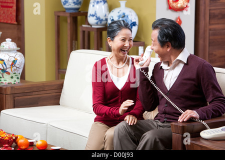 Aufgeregt, älteres Paar am Telefon während Chinese New Year Stockfoto